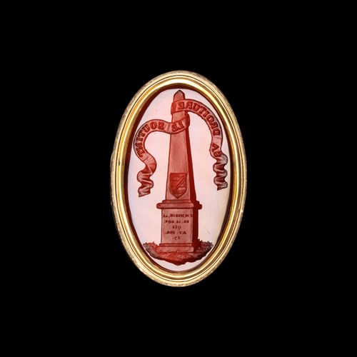 A gold ring set with a Grand Tour carnelian intaglio. Obelisk with coat arms.